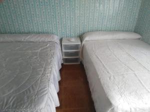 2 aparte bedden in een kamer met groen behang bij 3 bedroom house near beach lighthouse hiking trail in Corme-Puerto