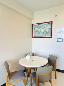 une chambre avec une table et des chaises et une photo sur le mur dans l'établissement Condo in Mactan Newtown with pool and beach access, à Mactan