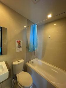 La salle de bains est pourvue de toilettes, d'un lavabo et d'une baignoire. dans l'établissement Condo in Mactan Newtown with pool and beach access, à Mactan