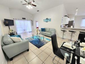 een woonkamer met een bank en een tafel bij Home Close to Disney Parks/Amazing Private Pool in Orlando