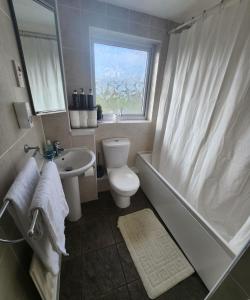 a bathroom with a toilet and a tub and a sink at Home in Medway 3bedroom free sports free parking in Chatham
