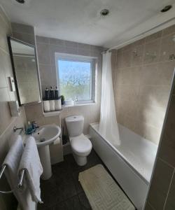 a bathroom with a toilet and a tub and a sink at Home in Medway 3bedroom free sports free parking in Chatham