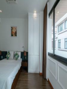 ein Schlafzimmer mit einem Bett und einem großen Fenster in der Unterkunft Chuỗi Villa 6 Ngủ FLC - Bể bơi - Gara ô tô - Hạ Long in Hạ Long
