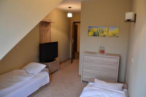 um quarto com duas camas e uma televisão e uma cómoda em Zagłoba Karczma em Opole