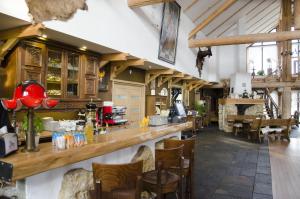 a restaurant with a bar with chairs and tables at Zagłoba Karczma in Opole