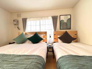富良野的住宿－FURANO BnB，一间卧室设有两张床和窗户。