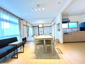 a living room with a table and a couch at FURANO BnB in Furano