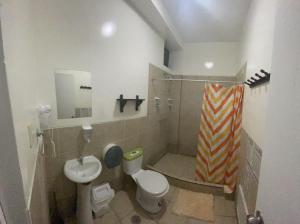 a bathroom with a toilet and a sink at Loki del Mar in Máncora