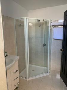 W łazience znajduje się prysznic ze szklanymi drzwiami. w obiekcie The Macquarie Hobart w mieście Hobart