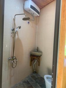 a bathroom with a shower and a toilet in it at Quế Homestay in Hòa Bình