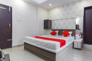 a bedroom with a large bed with red pillows at Flagship Aashirwad Guest House in Rānchī