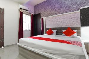 - une chambre avec un grand lit et des oreillers rouges dans l'établissement Flagship Aashirwad Guest House, à Rānchī