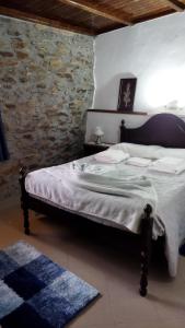 1 cama en un dormitorio con pared de piedra en O Recanto do Sobreiro, en Vale de Porco