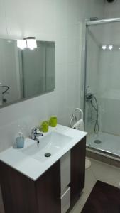 a white bathroom with a sink and a shower at O Recanto do Sobreiro in Vale de Porco