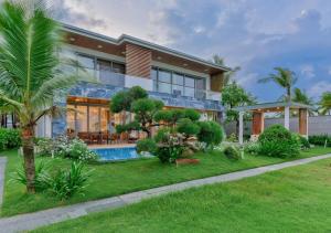 a house with a swimming pool in the yard at Deluxe Beachside Resort Danang in Danang