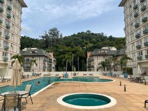 uma piscina no meio de dois edifícios em Loft luxuoso na Serra - Granja Brasil Resort em Petrópolis