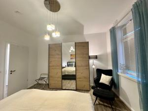 a bedroom with a bed and a chair and a mirror at Haus Concordia 2 Phönix in Thiessow
