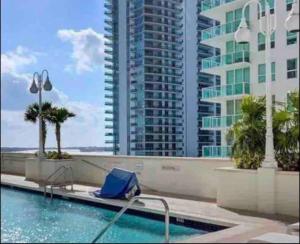 une piscine avec une chaise bleue et un bâtiment dans l'établissement PH 41st Floor 3 BED • Brickell • Ocean View, à Miami