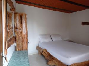 a bed in a room with a wooden frame at Alojamiento Rural Altos del Molino in Los Andes