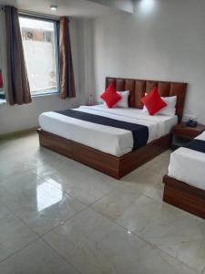 1 dormitorio con 2 camas y almohadas rojas en OYO Hotel Aerotech, en Nueva Delhi