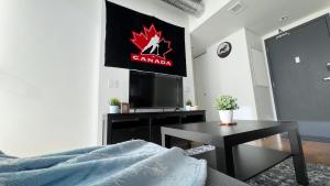 una camera con letto, TV e tavolo di Cozy 1BR Apt - Downtown Winnipeg a Winnipeg