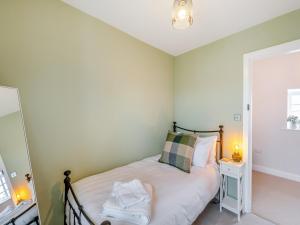 um pequeno quarto com uma cama e um espelho em Thirlwell em Ridingmill