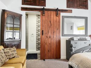 a living room with a wooden door and a couch at Smithy Apartment in Matlock