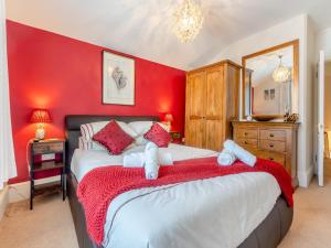 a red bedroom with a large bed with red walls at Casa Musica in Broadstairs