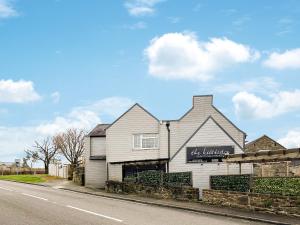 a white building on the side of a street at Smithy Apartment in Matlock