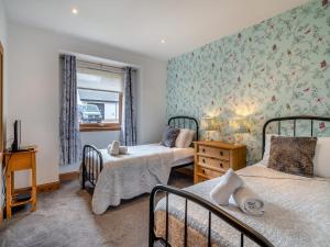 a bedroom with two beds and a window at Cairn View - S4402 in Aviemore