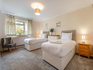 a hotel room with two beds and a chair at Little Hill Farm Villa in Ringwood