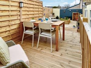 a patio with a wooden table and chairs at Yardie View in Buckie