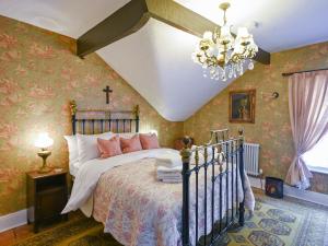 1 dormitorio con 1 cama y 1 cruz en la pared en St Marys Chambers, en Mold