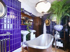 y baño con azulejos morados, bañera y lavabo. en St Marys Chambers en Mold