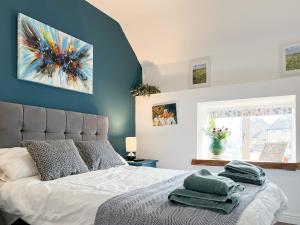 a bedroom with a bed with a blue wall at Holly Cottage in Ashover