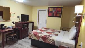 ein Hotelzimmer mit einem Bett und einem Schreibtisch mit einem Computer in der Unterkunft Deep River Motel in Deep River