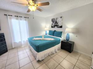 een slaapkamer met een bed en een plafondventilator bij Home Close to Disney Parks/Amazing Private Pool in Orlando +75 foto's