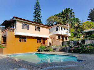 a house with a swimming pool in front of a house at Villa Marinelli Bed and Breakfast in Tagaytay