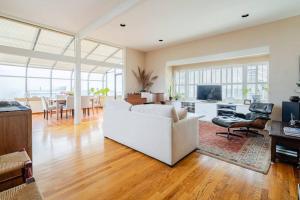 uma sala de estar com um sofá branco e uma mesa em Dreamy 3-Story House : Sunroom + City Skyline View em São Francisco