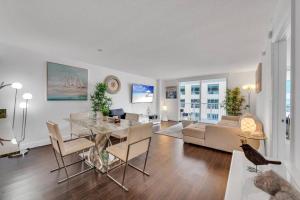 een eetkamer en een woonkamer met een tafel en stoelen bij Dazzling 1 BED 1 BTH • Brickell • Bay & City View in Miami