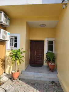 una puerta delantera de una casa con dos macetas en Dvyne Luxury Home en Ikeja
