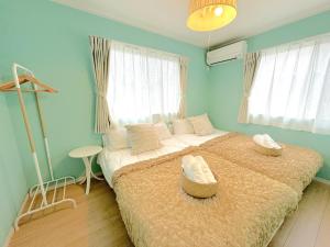 sypialnia z dużym łóżkiem z 2 krzesłami w obiekcie グランディオーソ沖縄ヴィラ恩納2 w mieście Onna