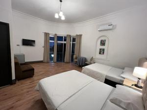 een hotelkamer met 2 bedden en een woonkamer bij Perla Suites Malecón in Guayaquil