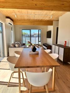 a dining room with a wooden table and white chairs at Stylish 3-bed Taradale Townhouse in Napier