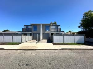 a house with a white fence in front of it at Stylish 3-bed Taradale Townhouse in Napier