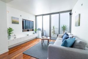 - un salon avec un canapé et une télévision dans l'établissement Heritage terrace with mod twist, à Hobart