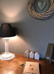 a table with a lamp and a guest book on it at Cosy Country Stay B&B in Matamata