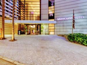 聖保羅的住宿－Hotel M-RCURE - Av Paulista - GRAND PLAZA - Deluxe king Studio Veranda - BATH SPA - Executive Class - By LuXXoR，一座大建筑的侧面有标志