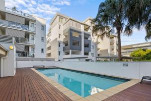 an apartment with a swimming pool in front of a building at South Vale Apartments South Brisbane in Brisbane