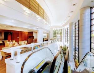 聖保羅的住宿－Hotel M-RCURE - Av Paulista - GRAND PLAZA - Deluxe king Studio Veranda - BATH SPA - Executive Class - By LuXXoR，大型客房设有带桌椅的自助餐厅。